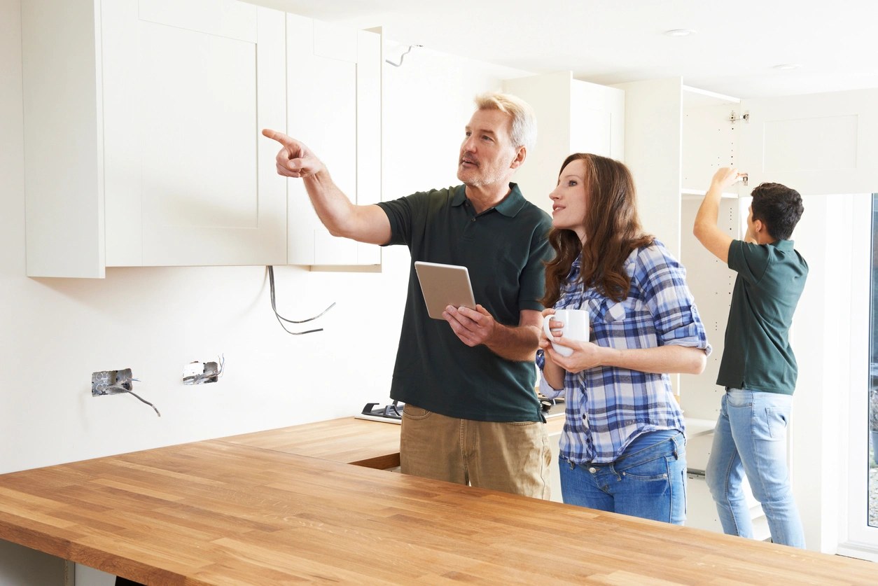 Designer walking homeowners through a kitchen layout during cabinet installation